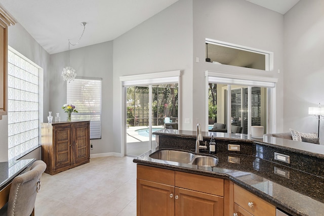 12341 NW 78th Mnr, Parkland, FL 33076 - kitchen with a sink, dark stone counters, pendant lighting, light tile patterned floors, and brown cabinets