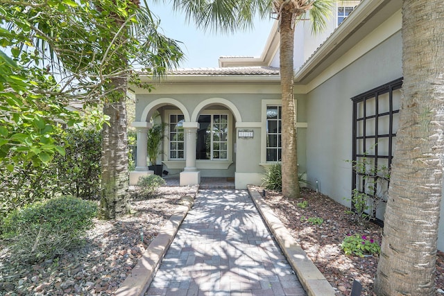 12341 NW 78th Mnr, Parkland, FL 33076 - view of exterior entry with a tiled roof, stucco siding, and covered porch
