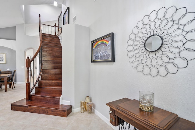 12341 NW 78th Mnr, Parkland, FL 33076 - stairway featuring arched walkways, tile patterned flooring, baseboards, and high vaulted ceiling