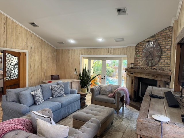 14324 Paddock Dr, Wellington, FL 33414 - living room with crown molding, stone tile flooring, a brick fireplace, wooden walls, and french doors