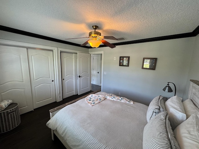14324 Paddock Dr, Wellington, FL 33414 - bedroom with multiple closets, dark wood-type flooring, crown molding, a ceiling fan, and a textured ceiling