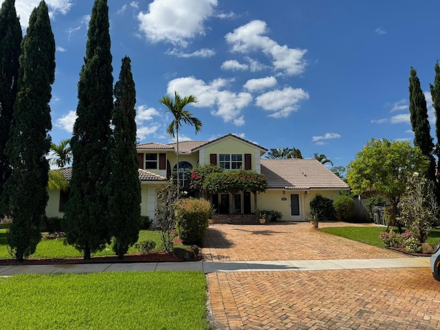 14324 Paddock Dr, Wellington, FL 33414 - view of front facade featuring a tiled roof, stucco siding, and decorative driveway