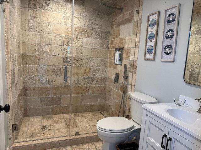 14324 Paddock Dr, Wellington, FL 33414 - bathroom with toilet, a shower stall, vanity, and stone finish flooring