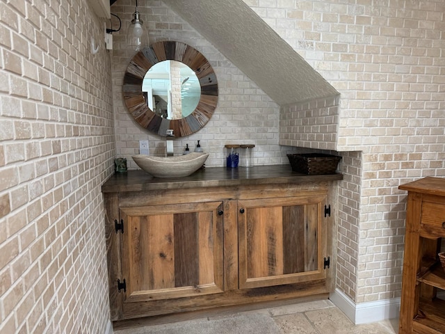14324 Paddock Dr, Wellington, FL 33414 - bar area with brick wall, a sink, and stone tile floors