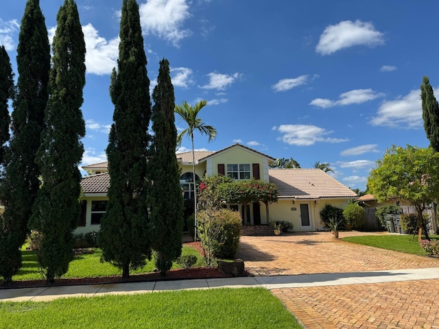 14324 Paddock Dr, Wellington, FL 33414 - view of front facade featuring a tile roof, stucco siding, decorative driveway, and a front yard