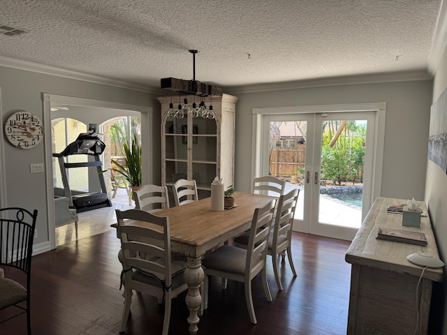 14324 Paddock Dr, Wellington, FL 33414 - dining space with french doors, crown molding, dark wood-style flooring, and a textured ceiling