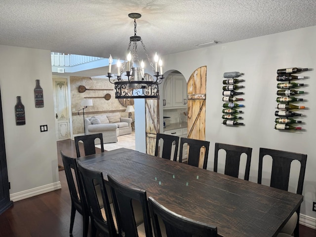 14324 Paddock Dr, Wellington, FL 33414 - dining space with a chandelier, dark wood-type flooring, a textured ceiling, and baseboards