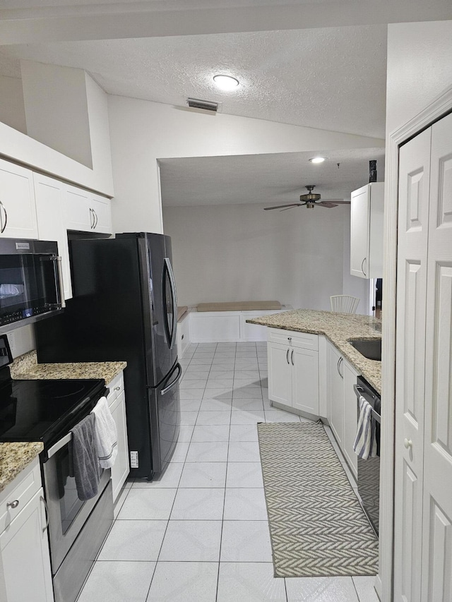 389 SE Whitmore Dr, Port Saint Lucie, FL 34984 - kitchen with stainless steel appliances, lofted ceiling, white cabinetry, a peninsula, and a ceiling fan