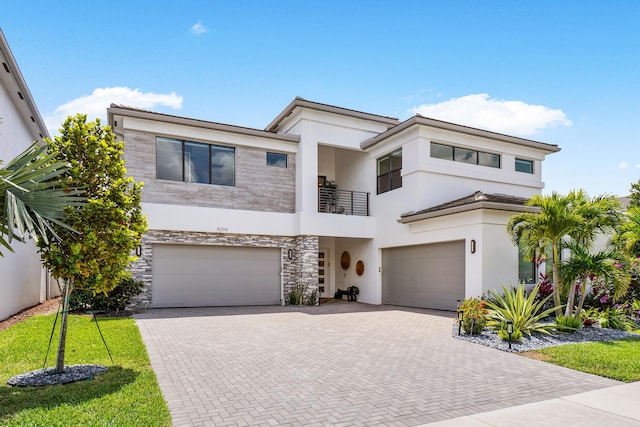 8294 Fishhawk Falls Ct, Boca Raton, FL 33496 - view of front facade with a balcony, a garage, stone siding, and decorative driveway