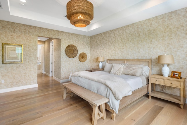 8294 Fishhawk Falls Ct, Boca Raton, FL 33496 - bedroom with wallpapered walls, light wood-type flooring, a tray ceiling, and baseboards