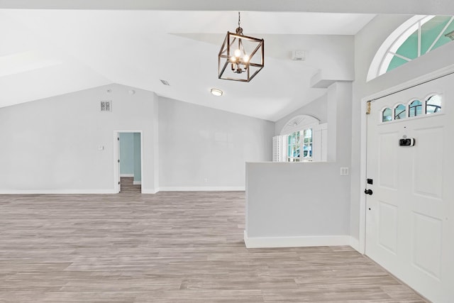 139 NE Royce Ave, Port Saint Lucie, FL 34983 - entryway featuring a chandelier, baseboards, wood finished floors, and high vaulted ceiling