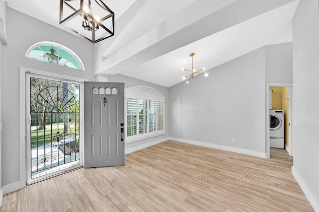 139 NE Royce Ave, Port Saint Lucie, FL 34983 - entryway featuring a chandelier, high vaulted ceiling, baseboards, light wood finished floors, and washer / dryer