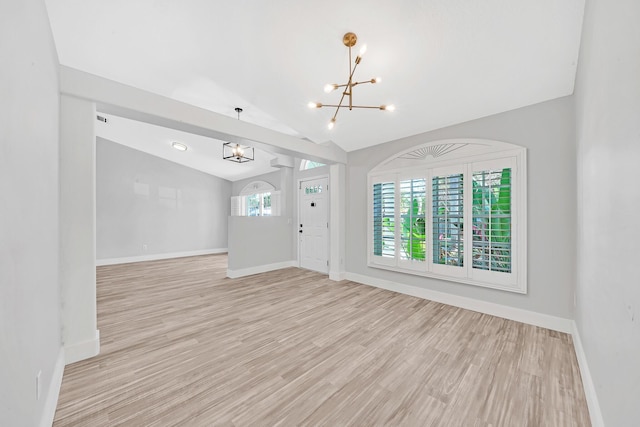 139 NE Royce Ave, Port Saint Lucie, FL 34983 - entrance foyer featuring a chandelier, lofted ceiling, light wood-style flooring, and baseboards