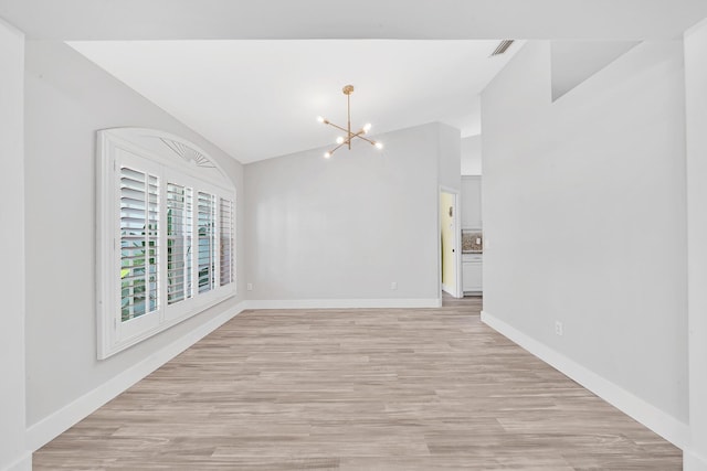 139 NE Royce Ave, Port Saint Lucie, FL 34983 - unfurnished room with a chandelier, light wood finished floors, baseboards, and high vaulted ceiling