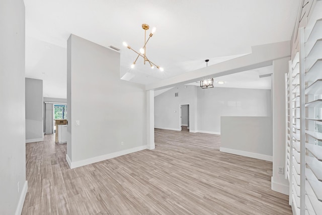139 NE Royce Ave, Port Saint Lucie, FL 34983 - unfurnished living room featuring a chandelier, light wood finished floors, vaulted ceiling, and baseboards