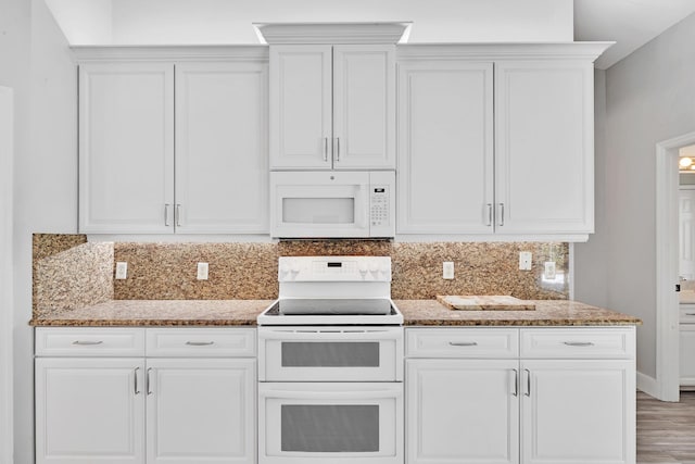 139 NE Royce Ave, Port Saint Lucie, FL 34983 - kitchen featuring white appliances, dark stone countertops, backsplash, and white cabinets