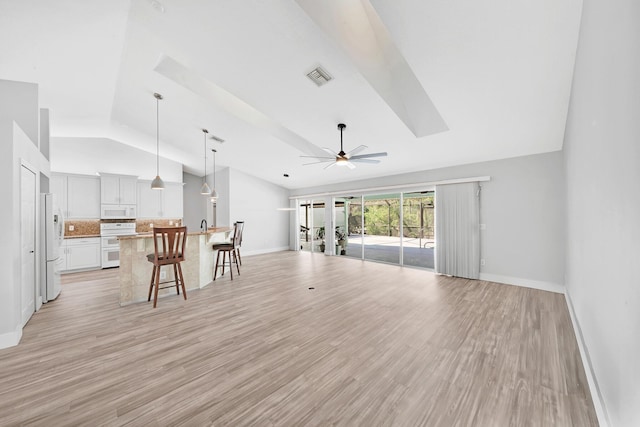 139 NE Royce Ave, Port Saint Lucie, FL 34983 - living room with baseboards, ceiling fan, light wood-type flooring, and high vaulted ceiling