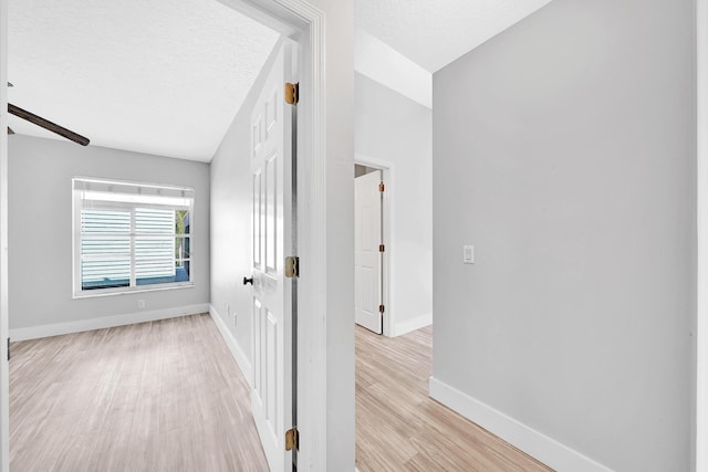 139 NE Royce Ave, Port Saint Lucie, FL 34983 - hall with light wood-style floors, baseboards, and a textured ceiling