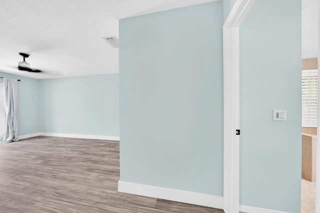 139 NE Royce Ave, Port Saint Lucie, FL 34983 - spare room featuring a textured ceiling, baseboards, and wood finished floors