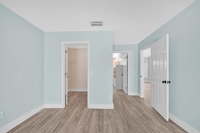 139 NE Royce Ave, Port Saint Lucie, FL 34983 - unfurnished bedroom featuring a spacious closet, light wood-style flooring, baseboards, and a closet