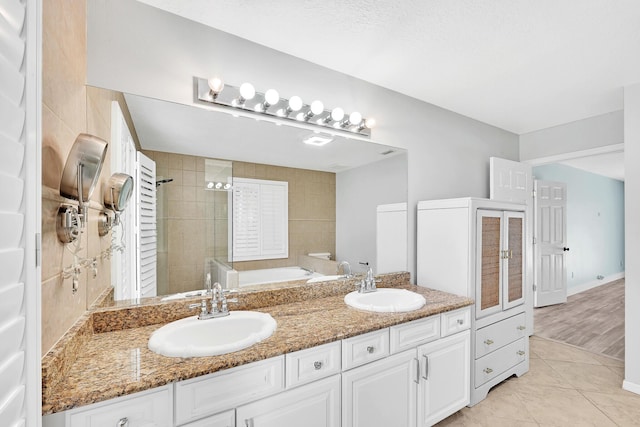 139 NE Royce Ave, Port Saint Lucie, FL 34983 - bathroom with double vanity, a garden tub, and tiled shower