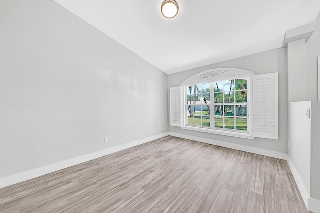 139 NE Royce Ave, Port Saint Lucie, FL 34983 - spare room featuring wood finished floors, vaulted ceiling, and baseboards