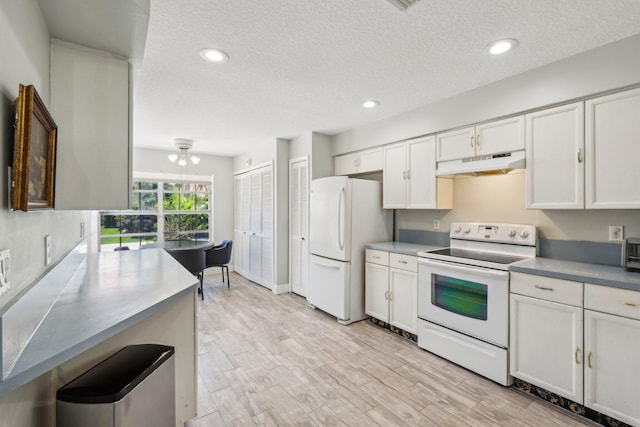 kitchen featuring white appliances, under cabinet range hood, a textured ceiling, recessed lighting, and white cabinets