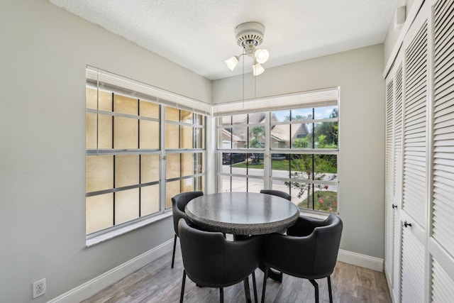 dining room featuring baseboards, a ceiling fan, and wood finished floors