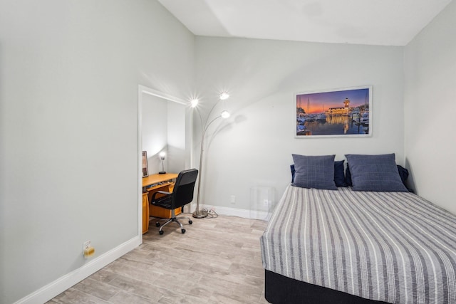 bedroom with baseboards, a desk, and wood finished floors