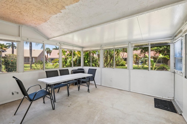 sunroom / solarium featuring outdoor dining area and vaulted ceiling
