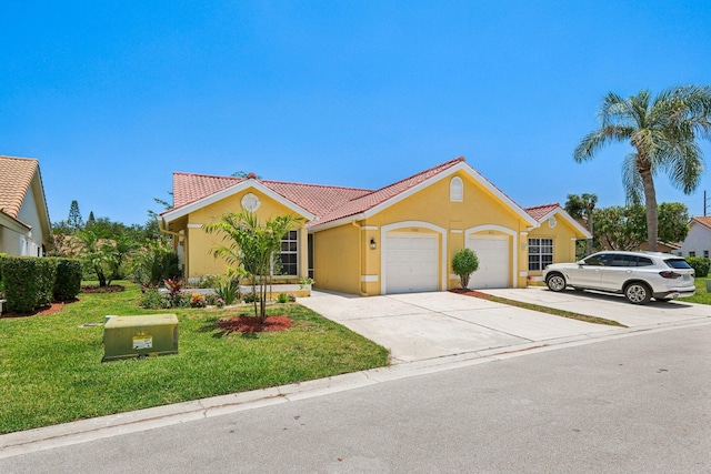 view of front of property with an attached garage, a front yard, stucco siding, driveway, and a tile roof