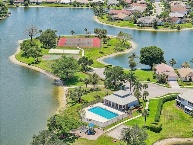 aerial perspective of suburban area with a pool and a large body of water