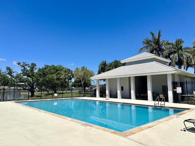 community pool featuring fence and a patio area