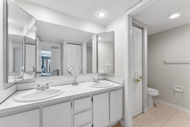 full bath featuring a closet, toilet, double vanity, and tile patterned floors