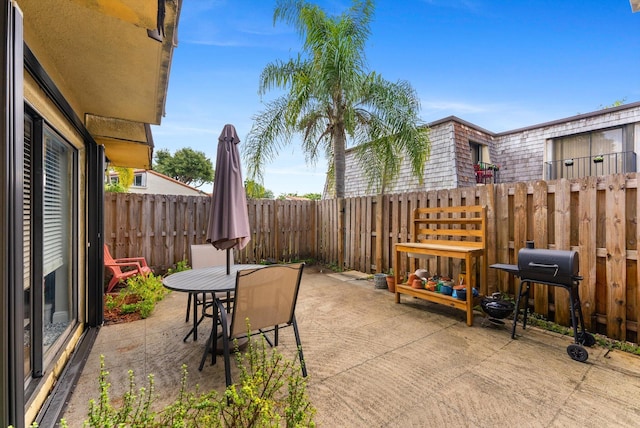 view of patio / terrace featuring grilling area, outdoor dining space, and a fenced backyard