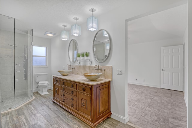 3035 Casa Rio Ct, Riviera Beach, FL 33418 - bathroom featuring toilet, a shower stall, baseboards, double vanity, and a textured ceiling
