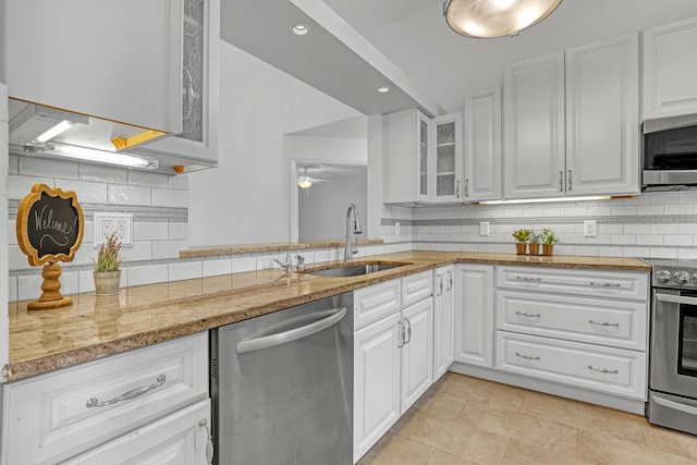 3035 Casa Rio Ct, Riviera Beach, FL 33418 - kitchen featuring stainless steel appliances, a sink, glass insert cabinets, a ceiling fan, and decorative backsplash