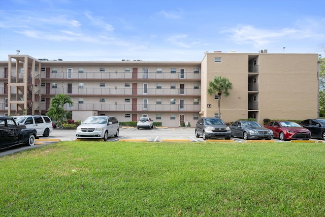 view of apartment building / complex with uncovered parking