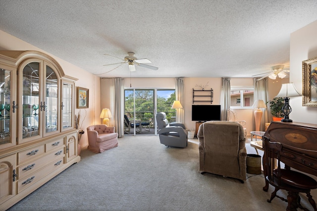 carpeted living area with a ceiling fan and a textured ceiling