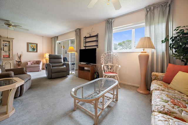 living room featuring a ceiling fan, carpet, and a textured ceiling