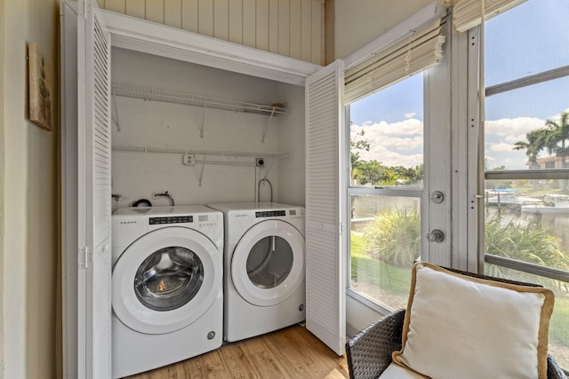 laundry room featuring independent washer and dryer, light wood-style flooring, and plenty of natural light