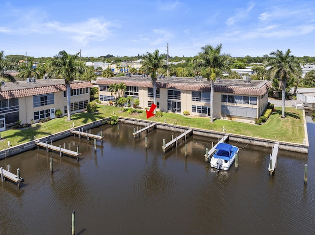 back of house featuring a water view, a tiled roof, and stucco siding