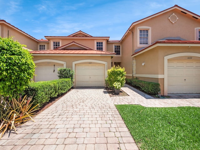 4167 Crystal Lake Dr, Deerfield Beach, FL 33064 - view of front of home featuring stucco siding, decorative driveway, and a standing seam roof