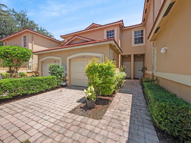 4167 Crystal Lake Dr, Deerfield Beach, FL 33064 - view of front of house featuring stucco siding, decorative driveway, and a garage