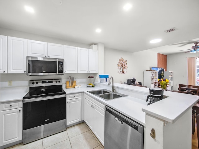 4167 Crystal Lake Dr, Deerfield Beach, FL 33064 - kitchen with appliances with stainless steel finishes, a sink, a peninsula, white cabinets, and recessed lighting