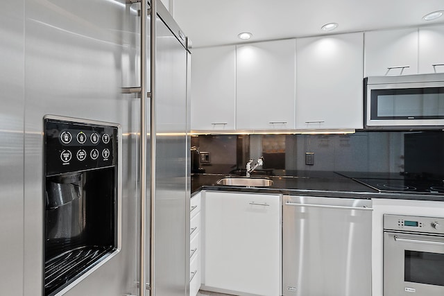 2780 S Ocean Blvd Unit 707, Palm Beach, FL 33480 - kitchen with stainless steel appliances, white cabinetry, dark countertops, modern cabinets, and backsplash