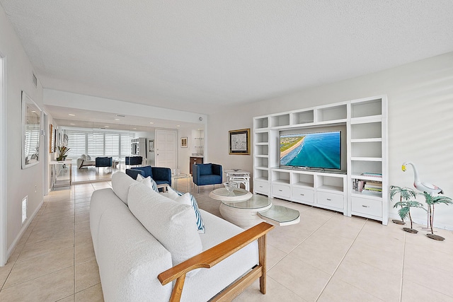 2780 S Ocean Blvd Unit 707, Palm Beach, FL 33480 - living room with light tile patterned floors, a textured ceiling, built in shelves, and baseboards