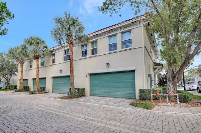 4128 Cascada Cir, Cooper City, FL 33024 - townhome / multi-family property with a garage, stucco siding, decorative driveway, and a tiled roof