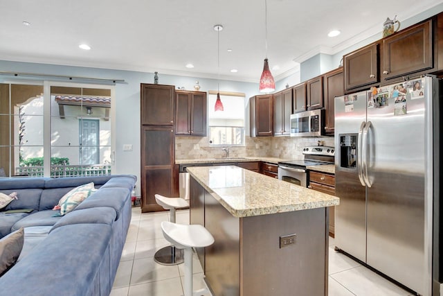 4128 Cascada Cir, Cooper City, FL 33024 - kitchen with stainless steel appliances, open floor plan, a sink, a kitchen island, and light tile patterned floors