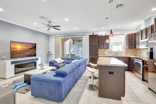 4128 Cascada Cir, Cooper City, FL 33024 - living room featuring ornamental molding, a ceiling fan, recessed lighting, a glass covered fireplace, and light tile patterned floors